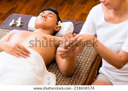 Indonesian Asian man in wellness beauty spa having aroma therapy hand massage with essential oil, looking relaxed
