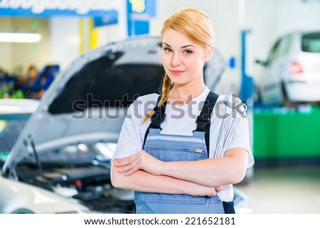 Female auto mechanic working in car workshop
