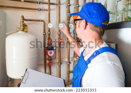 Engineer controlling the heating pipes at the boiler room