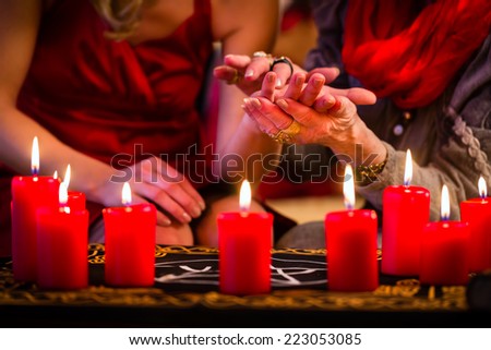 Female Fortuneteller or esoteric Oracle, sees in the future by hand reading during a Seance to interpret them and to answer questions