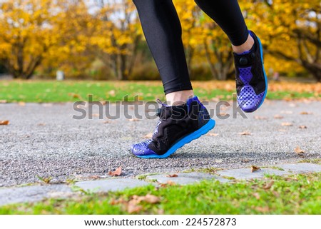 Woman sport running through autumn or fall park