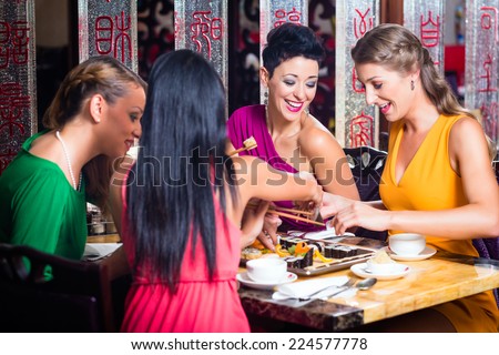 Young people eating sushi in Asian restaurant