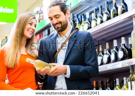 Couple selecting wine in supermarket
