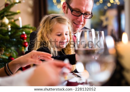 parents and children toasting with wine and water at Christmas eve dinner