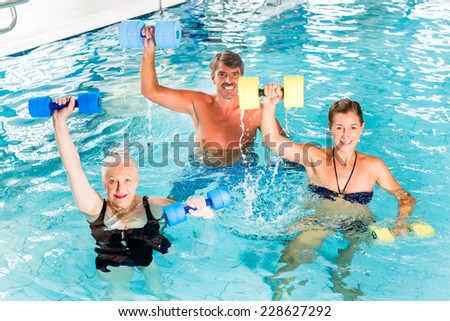 Group of people, mature man, young and senior women, at water gymnastics or aquarobics