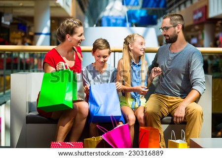 Family with kids shopping in mall having a break