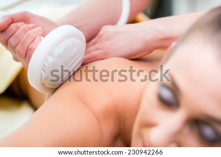 Woman having relaxing herbal bag back massage in wellness spa
