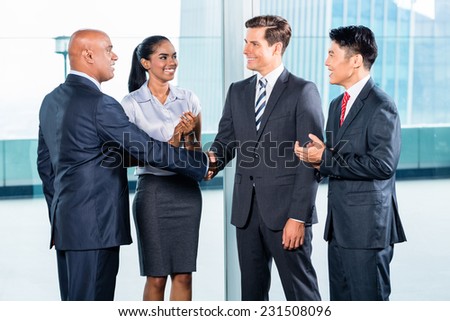 Diversity business team concluding contract with handshake in front of city skyline