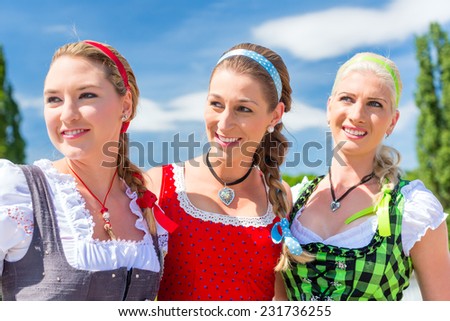 Friends visiting together Bavarian fair in national costume or Dirndl