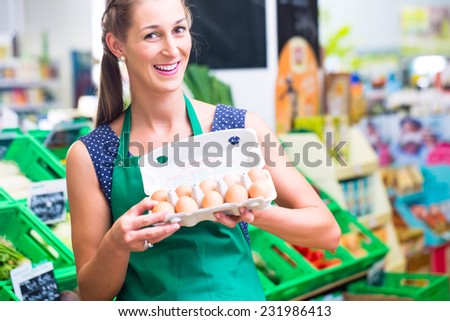 Female organic Supermarket clerk filling up egg storage racks in fresh department