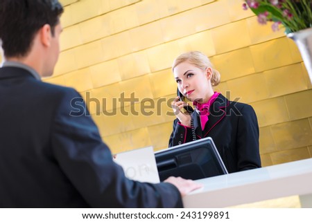 Hotel receptionist telephoning with guest for reservation or information