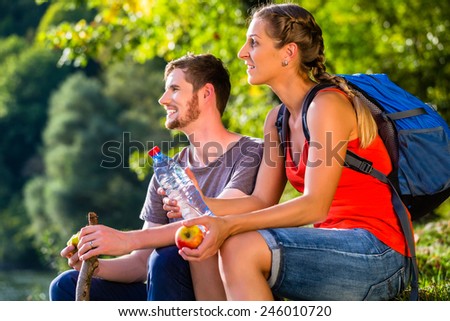 Couple hiking in summer drinking water