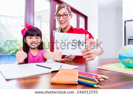 Teacher giving English language lessons to Chinese child