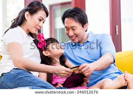 Chinese family online shopping with tablet computer and credit card