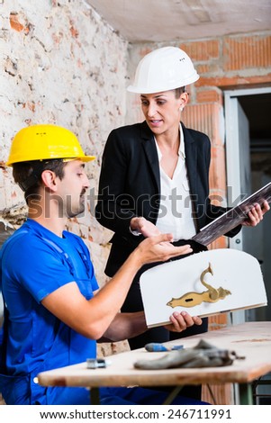 Construction worker and interior designer with door handle discussing door handles