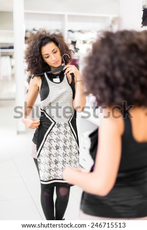 Woman shopping fashion, trying on dress in store