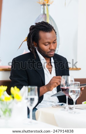 Business man, african american, with tablet in restaurant having lunch in restaurant