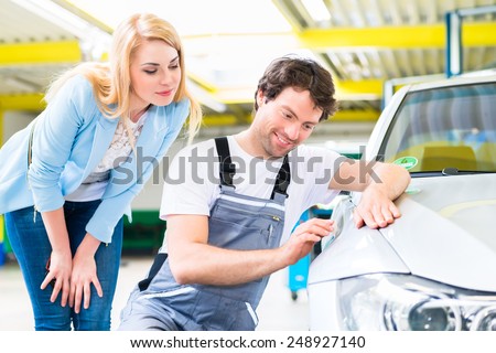 Male mechanic examine car finish on dents or scratches in workshop