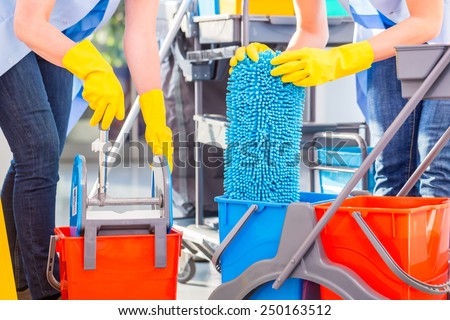 Cleaning ladies mopping floor, close up on hands and tools