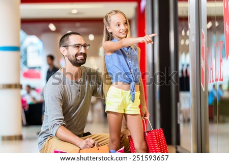 Family at shop window in mall shopping