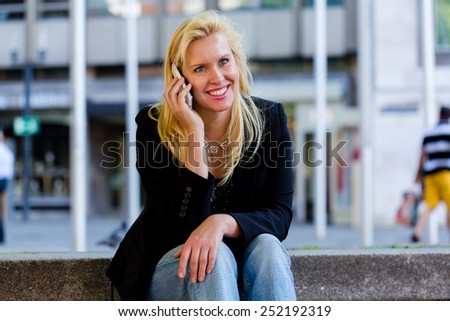 Mature woman telephoning with smartphone in city