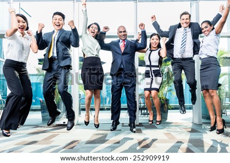 Diversity business team jumping celebrating success, Chinese, Indonesian, Indian, and Caucasian ethnicities