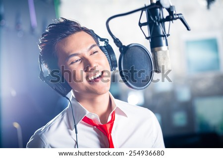 Asian professional musician recording new song or album CD in studio Asian professional musician recording new song or album CD in studio