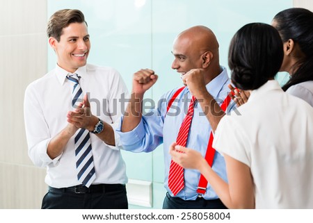 Business team celebrating success applauding and shaking fists