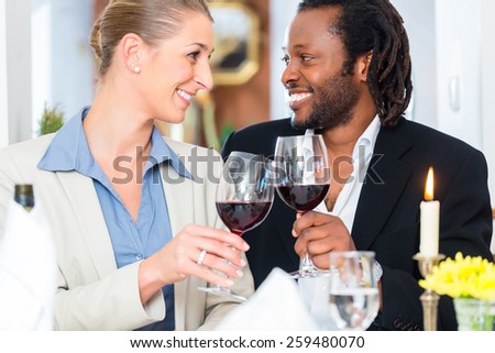 Business people, caucasian woman and african american man, toasting on deal with wine