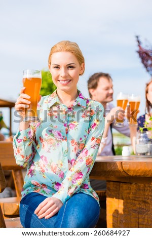 Woman drinking with friends in beer garden
