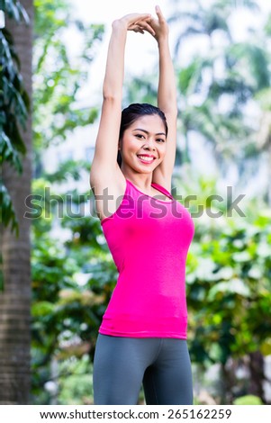 Asian Woman stretching in fitness exercise or sport training in tropical park