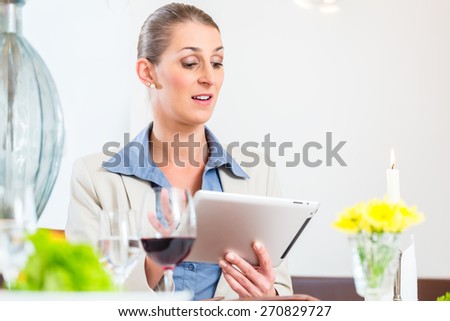 Business woman with tablet in restaurant eating lunch