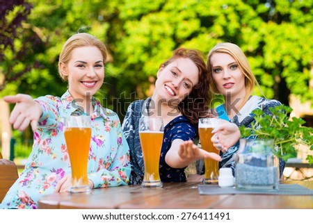 Friends talking and drinking in beer garden