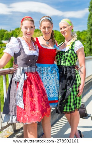 Friends visiting together Bavarian fair in national costume or Dirndl