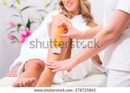 Woman receiving waxing for hair removal in beauty parlor