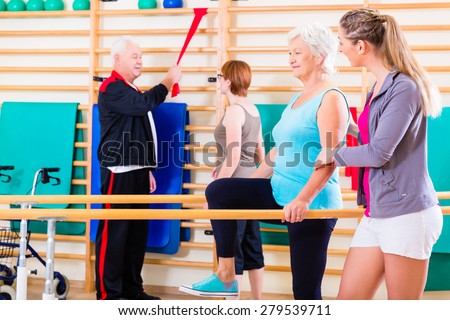 Seniors in physical rehabilitation therapy with trainer