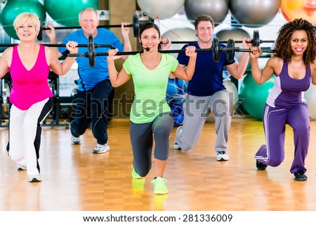 Men and women lifting barbell in gym, diversity group of old, young, black and white people