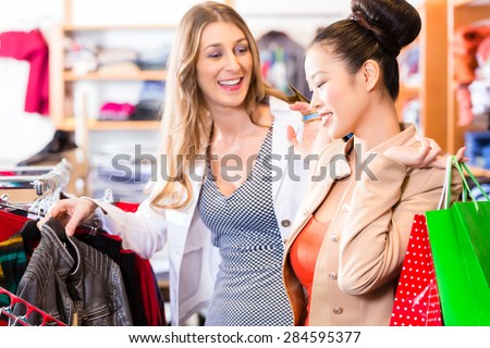 Asian and Caucasian Women friends shopping in boutique or fashion store