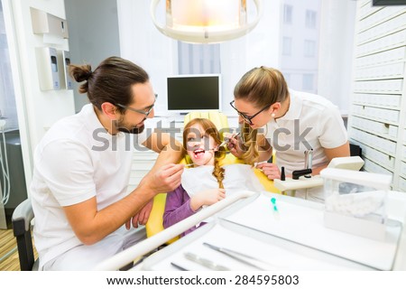 Dentist giving girl treatment  in dental surgery