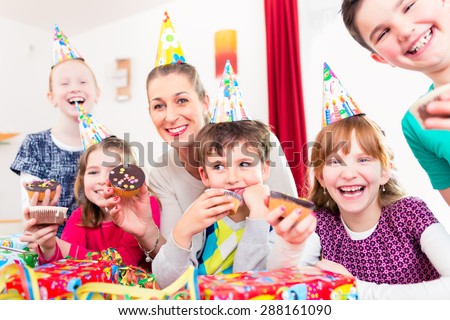 Children having cupcakes celebrating birthday on big party with all the friends and mom