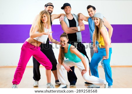 Young men and women dancing zumba modern group choreography in dance school