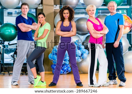 Diversity fitness group in gym, old and young, black and white people, doing sport in gymnastic training