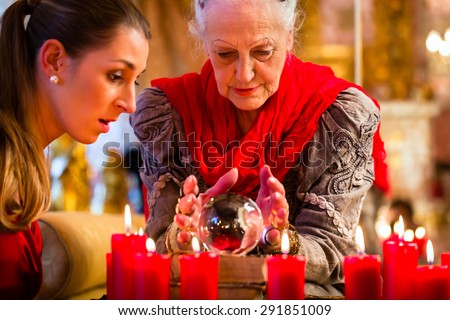 Female Fortuneteller or esoteric Oracle, sees in the future by looking into their crystal ball answering questions from client