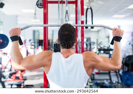 Man doing bodybuilding sport by exercising lifting dumbbells in fitness club or gym