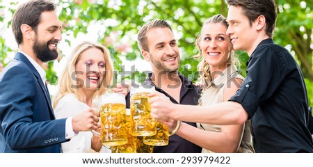 Friends or colleagues on beer garden after work toasting with drinks