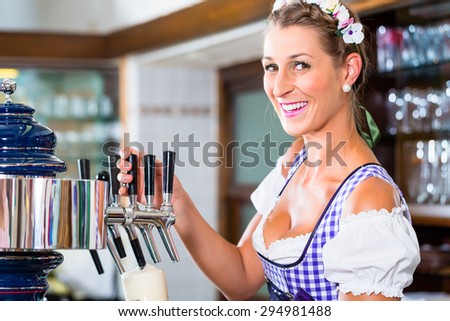 Innkeeper in Bavarian pub drawing beer