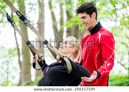 Sport woman with trainer at sling training