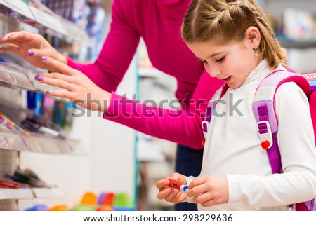 Family buying school supplies in stationery store, little girl looking at a fountain pen