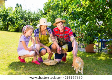 Family with cat gardening in garden