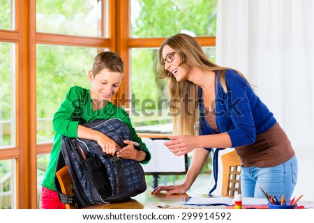 Mother and son packing school bag for next day